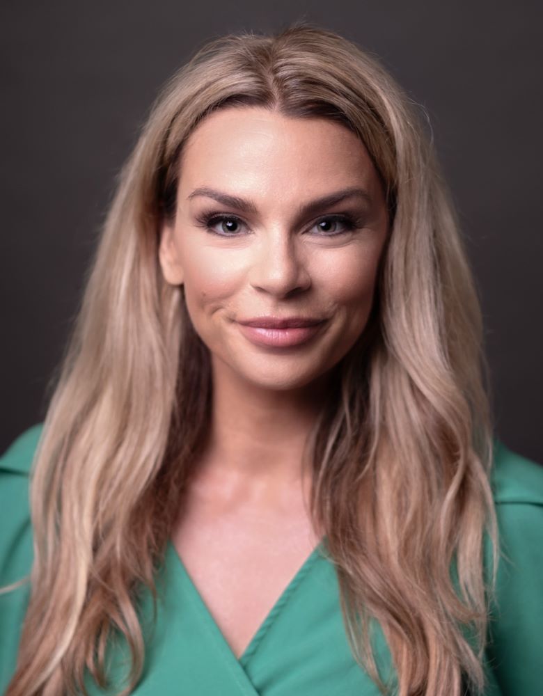 woman with long blond hair with teal colored shirt